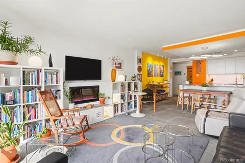 a kitchen that has a lot of white furniture wooden floor and a window