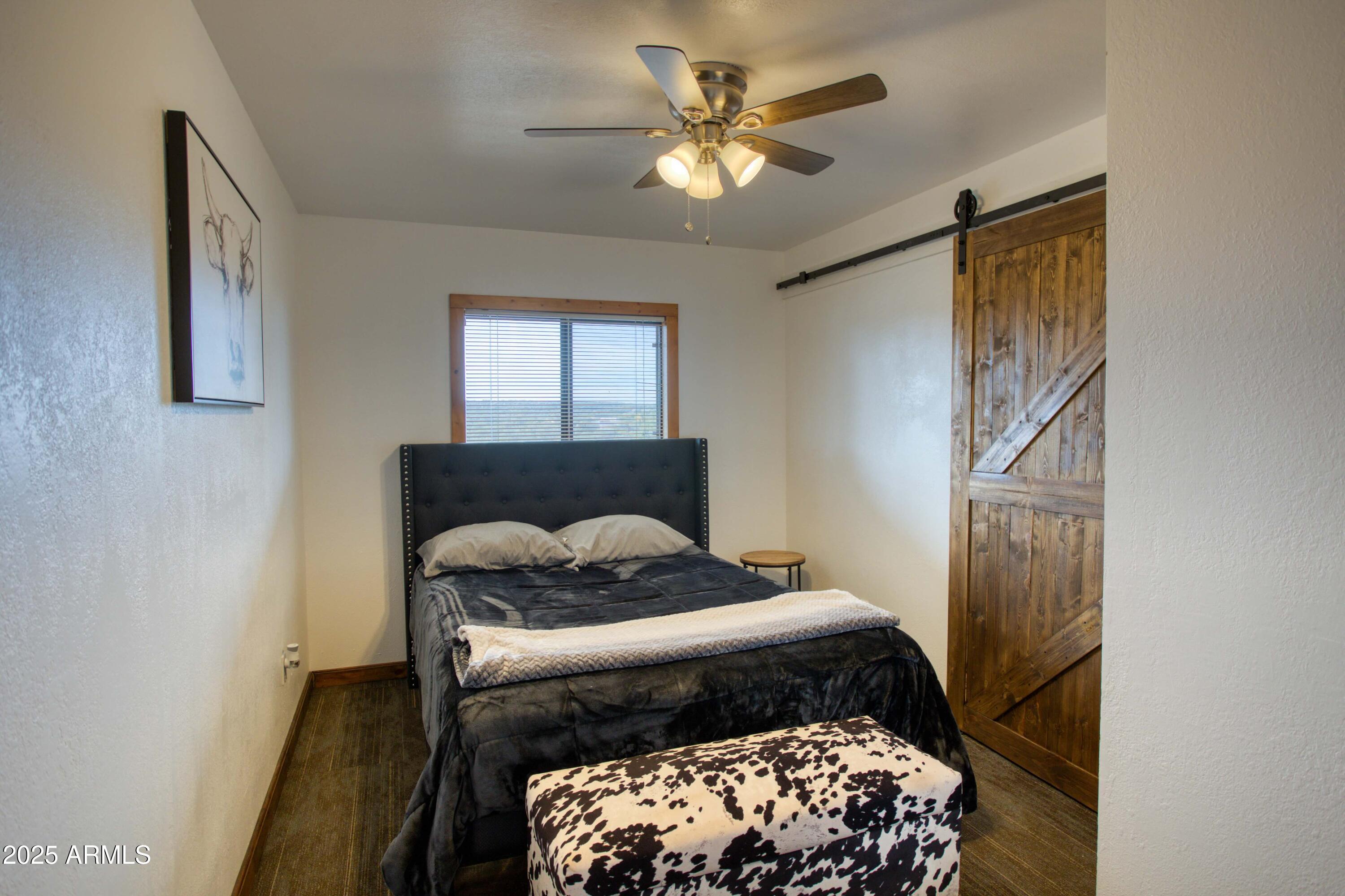 8286 Ridge Drive Show Low, AZ 85901 - Photo 11 of 21 a bedroom with a bed and a chandelier