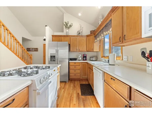 a kitchen with stainless steel appliances kitchen island granite countertop a sink stove and refrigerator