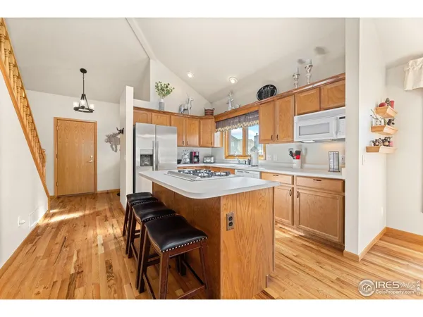 a kitchen with stainless steel appliances kitchen island granite countertop a sink and a refrigerator