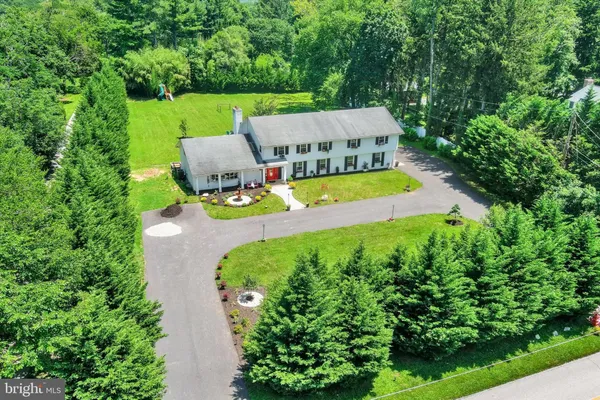 an aerial view of a house with swimming pool big yard and large trees