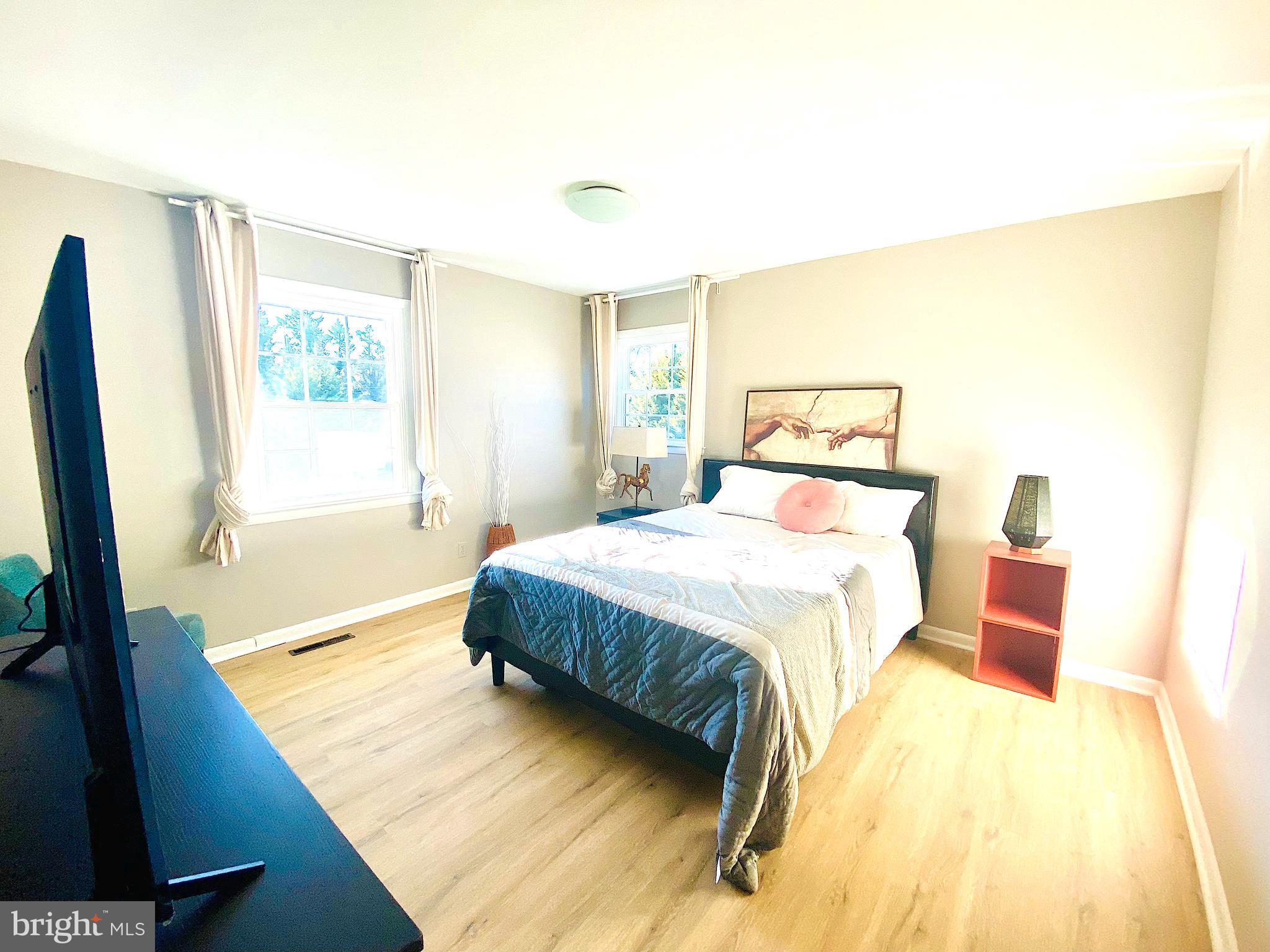 10533 Stevenson Road Stevenson, MD 21153 - Photo 23 of 45 a spacious bedroom with a bed and a flat tv screen on dresser