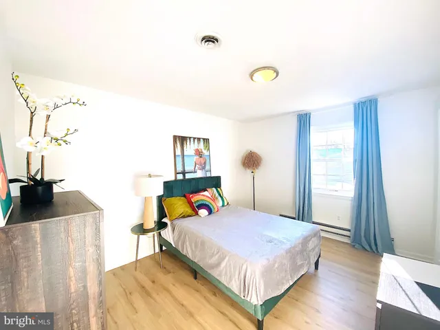 a bedroom with a bed and a dresser with mirror