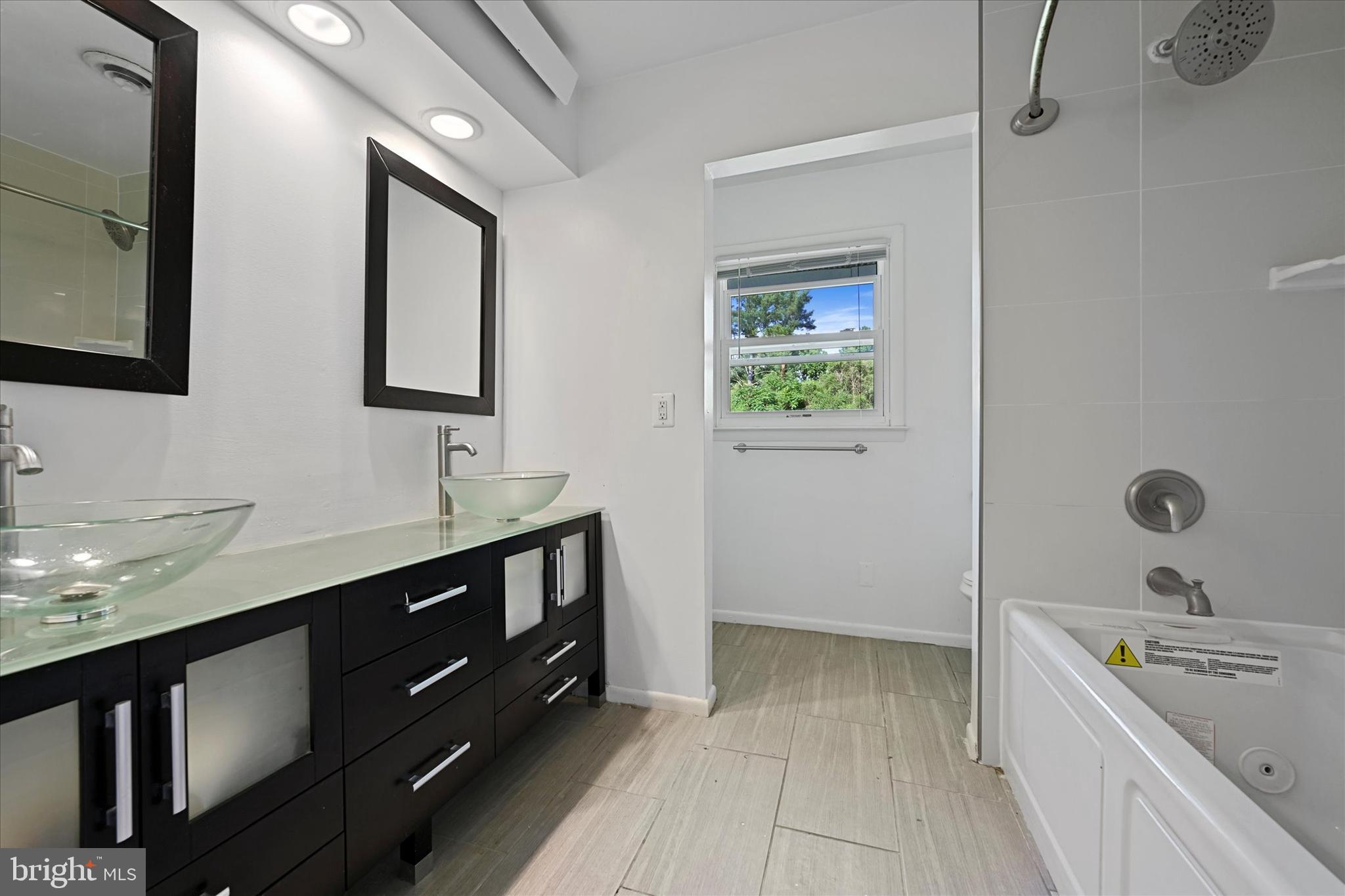 10533 Stevenson Road Stevenson, MD 21153 - Photo 31 of 45 a bathroom with a granite countertop sink mirror and bathtub