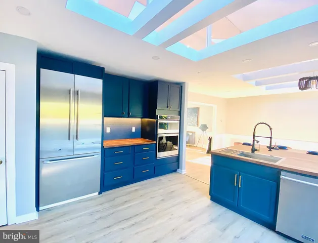 a kitchen with stainless steel appliances granite countertop a refrigerator and a sink