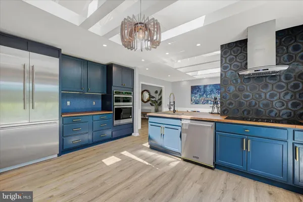 a kitchen with stainless steel appliances granite countertop a sink a counter space and cabinets