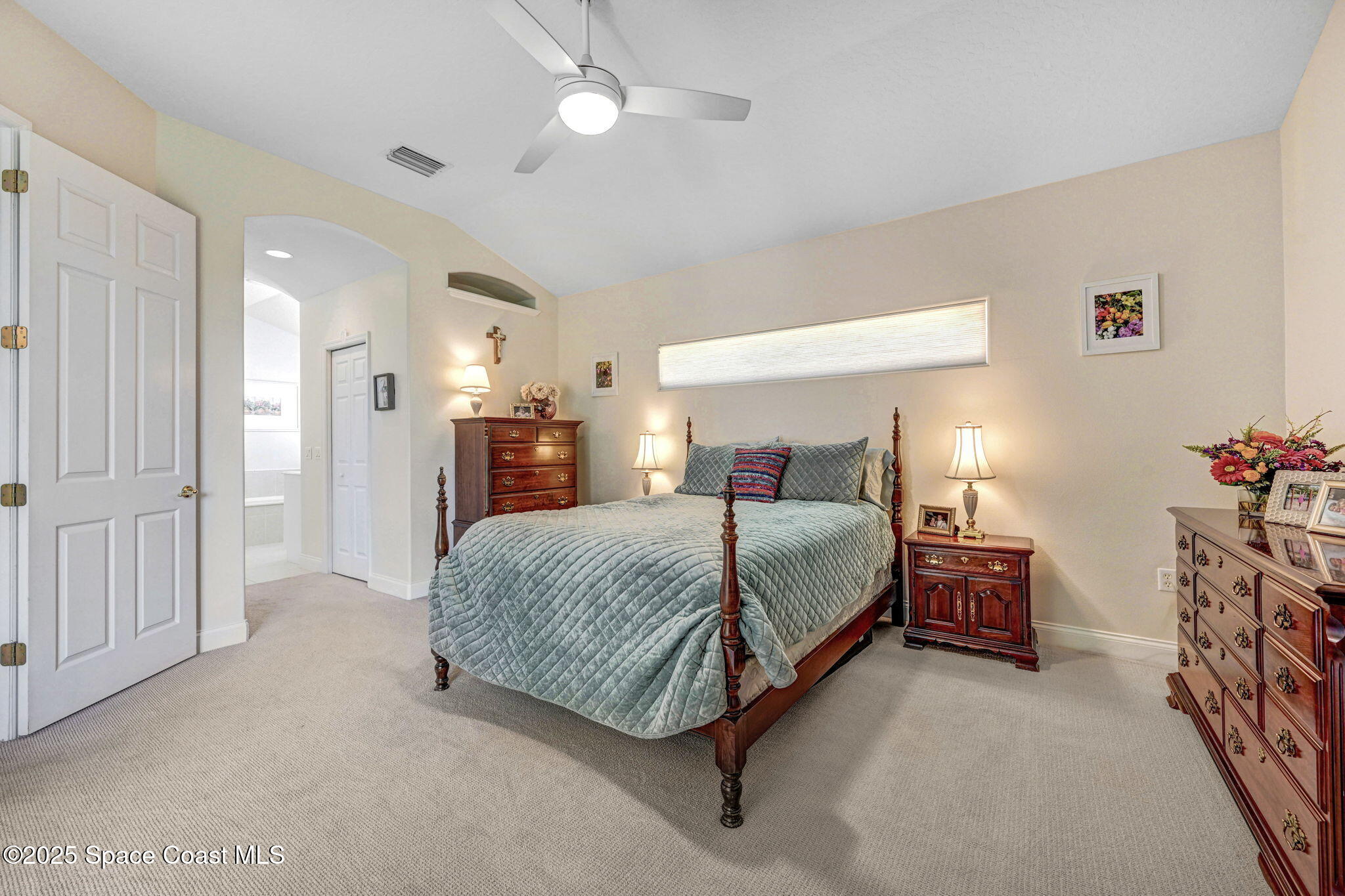 507 Royston Lane Melbourne, FL 32940 - Photo 37 of 52 a bedroom with a large bed and a chandelier