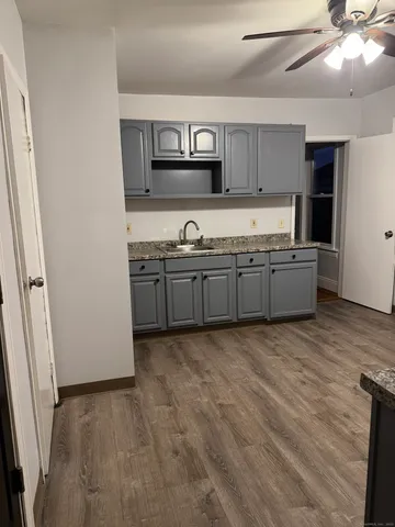 a large kitchen with granite countertop a sink and a stove top oven