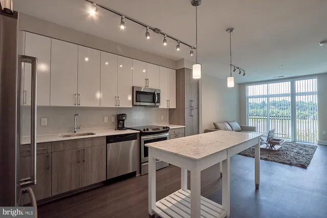 a kitchen with a stove a sink dishwasher a kitchen island with wooden cabinets and floor