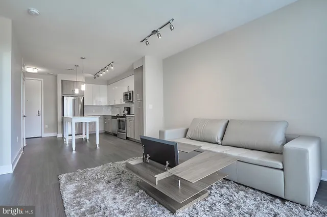 a living room with furniture and kitchen view