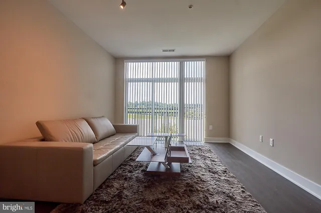 a living room with furniture and a floor to ceiling window
