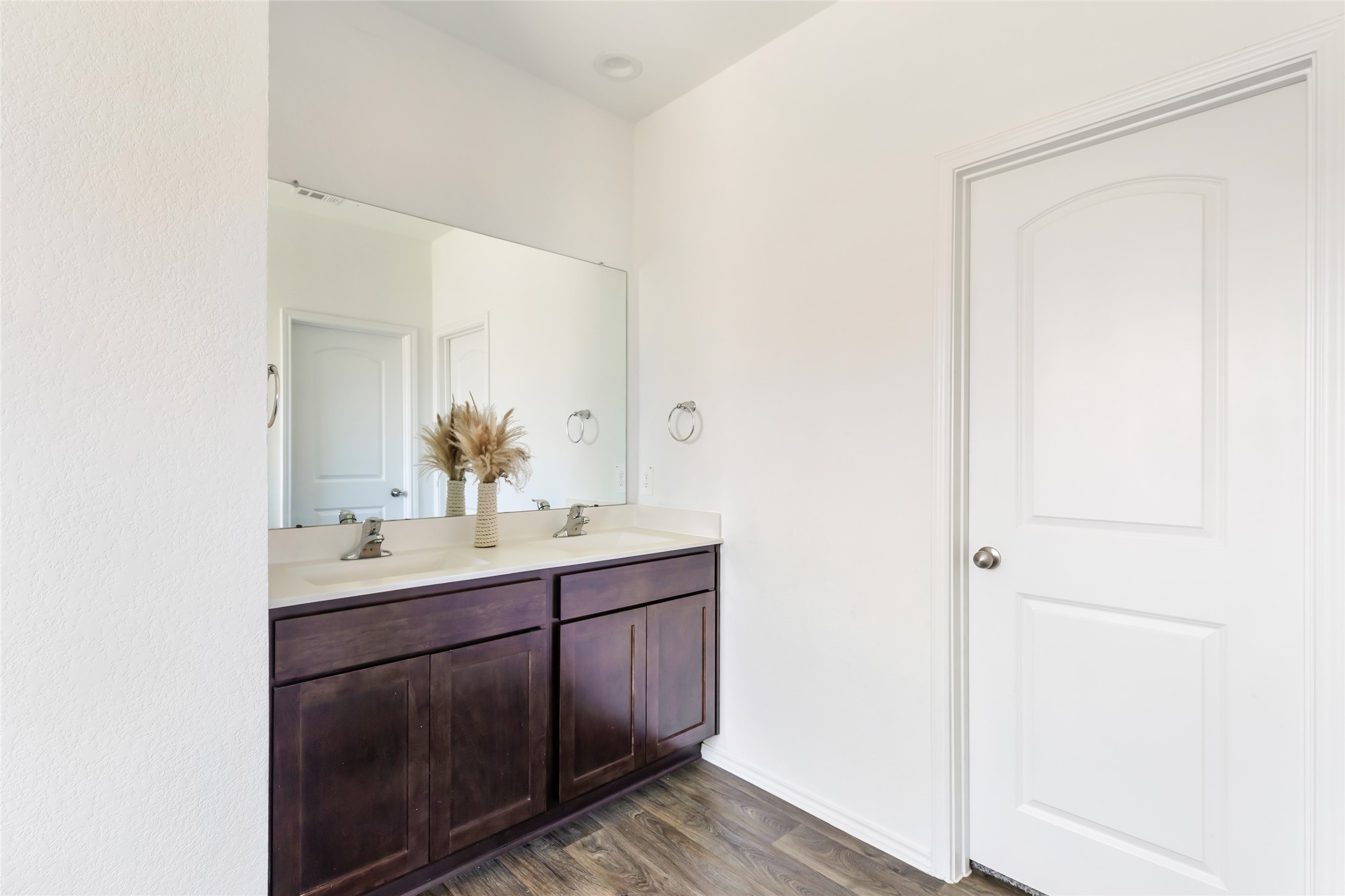 811 Republic Road New Caney, TX 77357 - Photo 36 of 37 This bathroom features a sleek double vanity with dark wood cabinets, a large mirror, and elegant fixtures. The neutral color palette and ample lighting create a bright and inviting space.