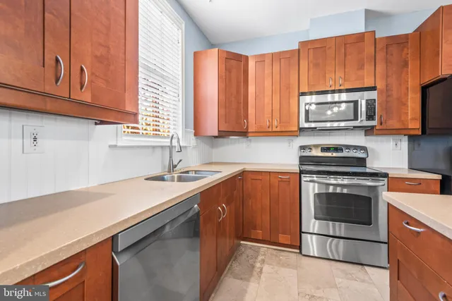 a kitchen with stainless steel appliances granite countertop a sink stove and microwave