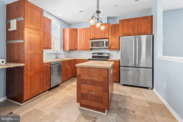 a kitchen with stainless steel appliances a refrigerator and a stove top oven