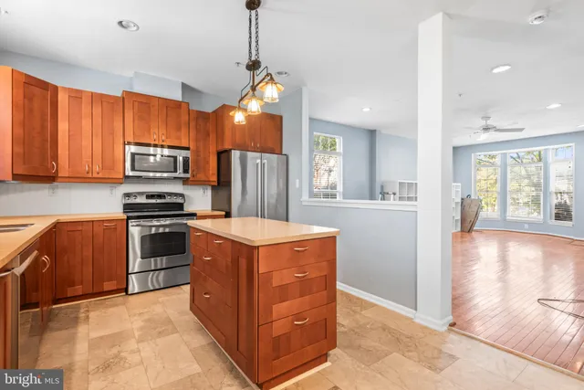 a kitchen with stainless steel appliances granite countertop a stove a sink and a refrigerator