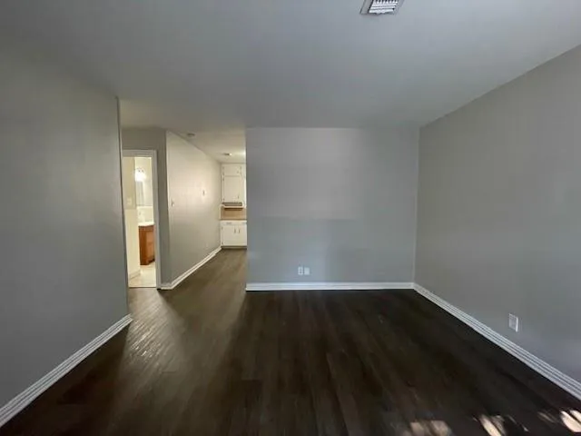 a view of a small space with wooden floor and a window