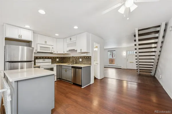 a kitchen with stainless steel appliances granite countertop a refrigerator and a stove top oven