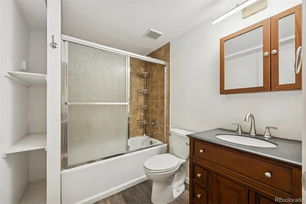 a bathroom with a toilet a sink and glass door