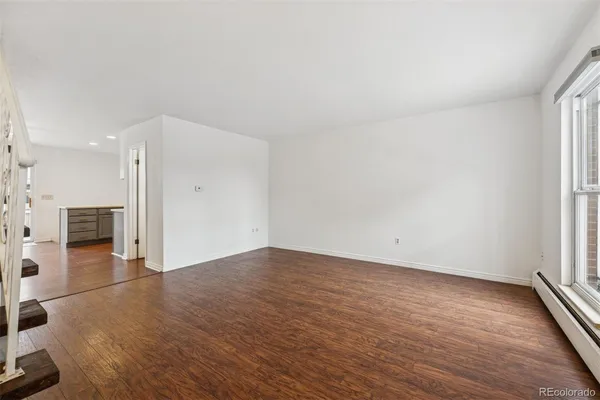 an empty room with wooden floor and fireplace