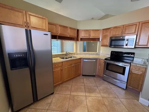 a kitchen with stainless steel appliances a refrigerator sink and microwave