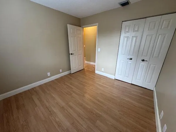 a view of an empty room with wooden floor