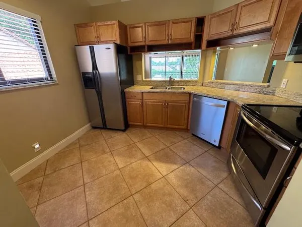 a kitchen with stainless steel appliances a sink a stove a microwave and a counter top