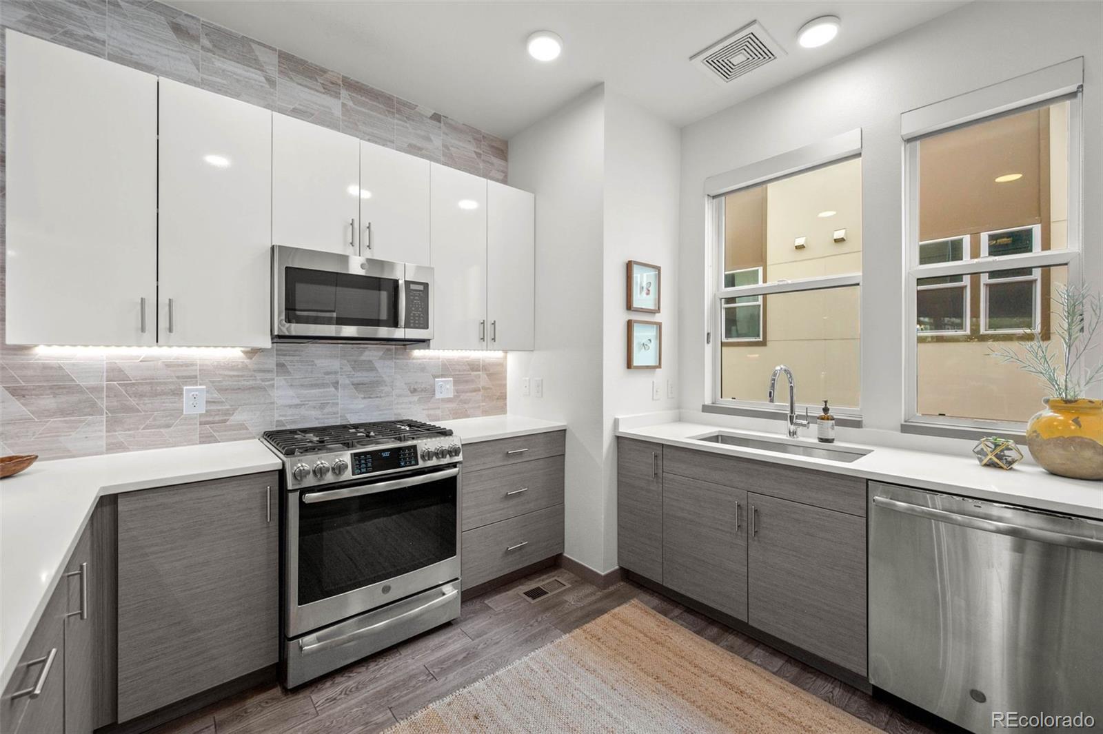 2200 Tremont Place, Unit 5 Denver, CO 80205 - Photo 9 of 22 a kitchen with stainless steel appliances a sink stove and microwave