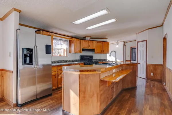 a large kitchen with stainless steel appliances granite countertop wooden cabinets a granite counter top and a stove