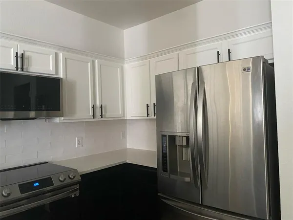 a kitchen with a refrigerator and cabinets