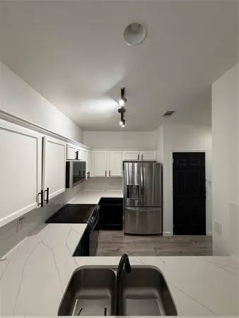 a large kitchen with a large window and stainless steel appliances