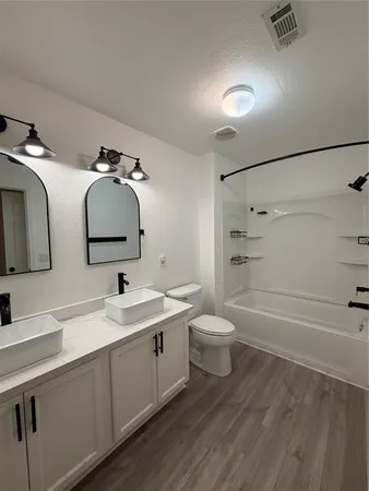 a bathroom with a double vanity sink mirror and toilet