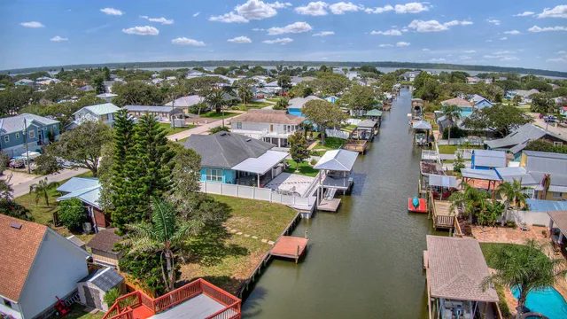 an aerial view of residential houses with outdoor space and lake view