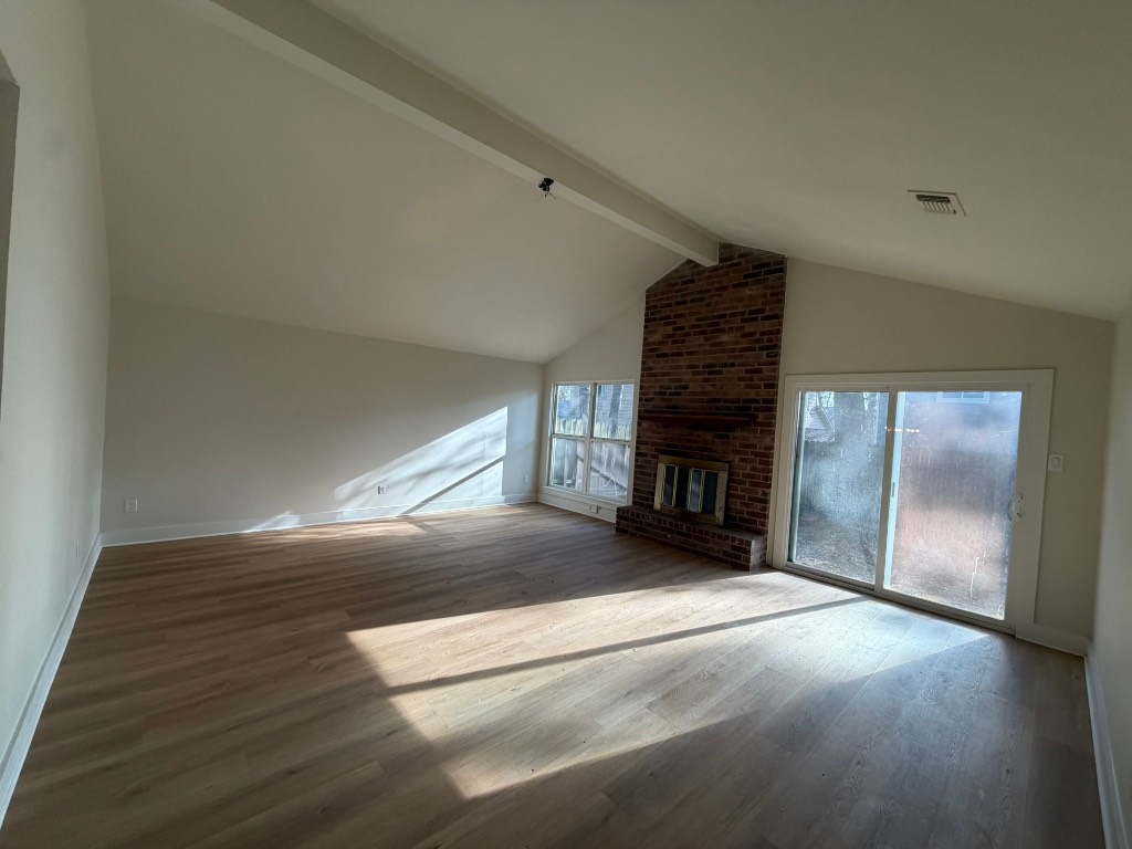 70 Brookflower Road Spring, TX 77380 - Photo 2 of 16 a view of an empty room with wooden floor fireplace and a window