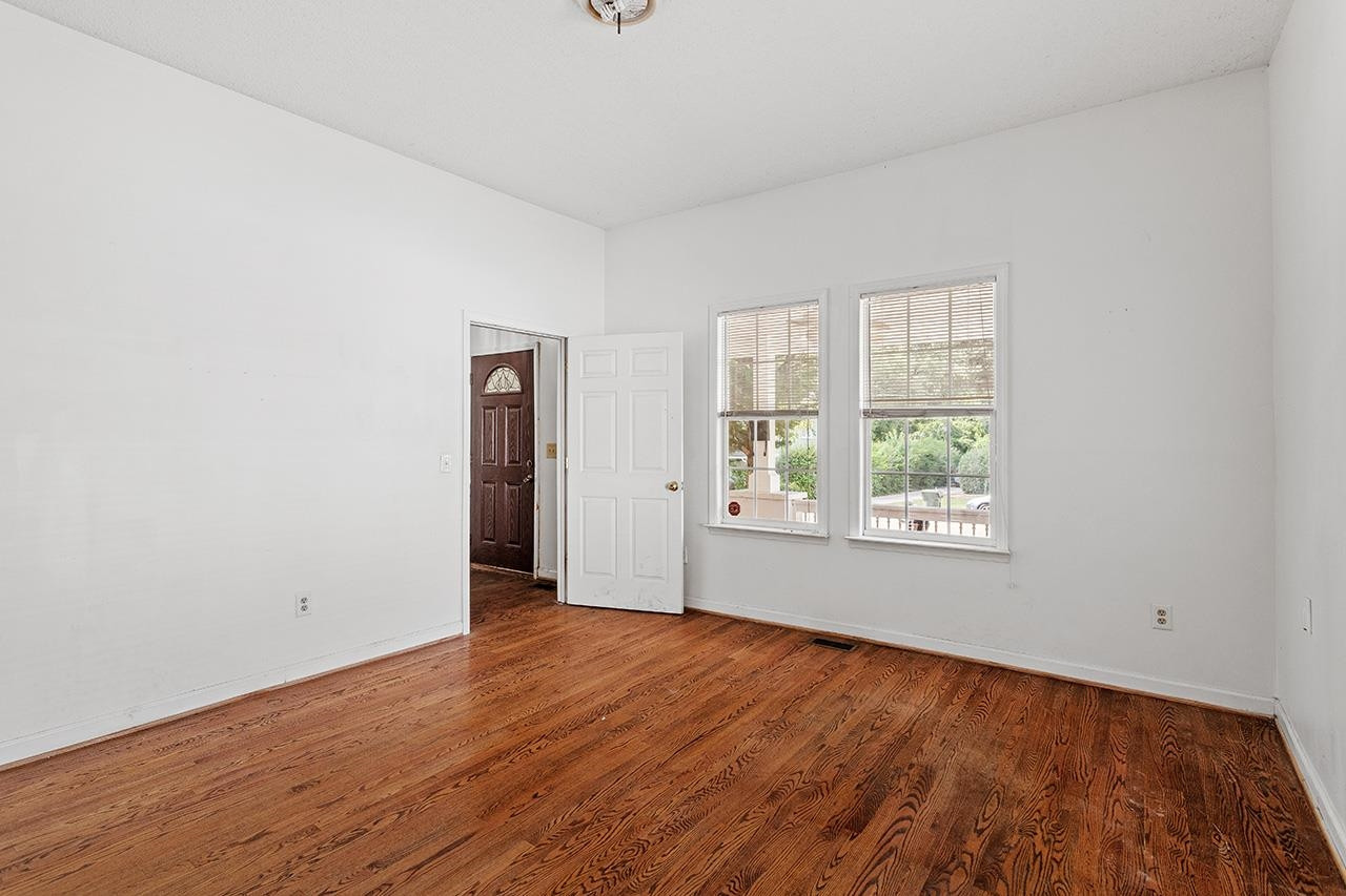 24 Dixie Trail Raleigh, NC 27607 - Photo 12 of 38 an empty room with wooden floor and windows
