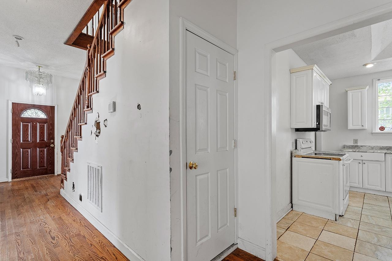 24 Dixie Trail Raleigh, NC 27607 - Photo 14 of 38 a view of a kitchen from the hallway with wooden floor and staircase