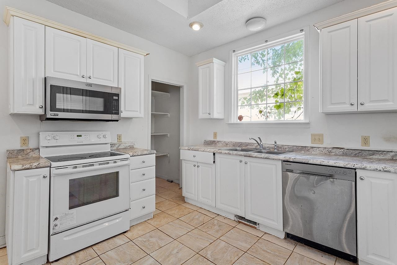 24 Dixie Trail Raleigh, NC 27607 - Photo 15 of 38 a kitchen with granite countertop white cabinets appliances a sink and a window