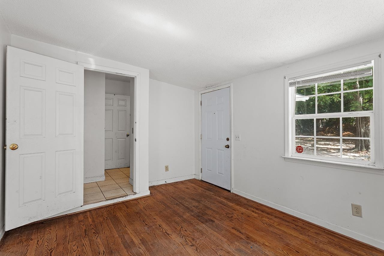 24 Dixie Trail Raleigh, NC 27607 - Photo 21 of 38 an empty room with wooden floor and windows