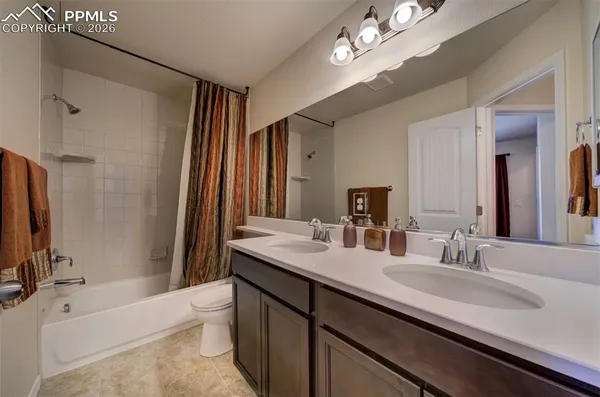 a bathroom with a sink double vanity granite tub and a mirror