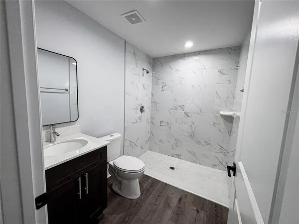 a bathroom with a sink a toilet and shower