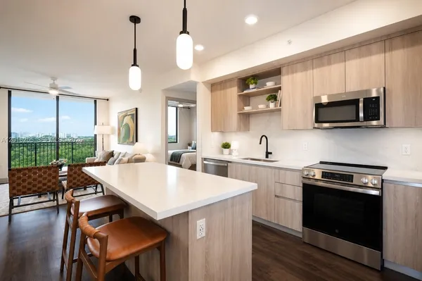 a kitchen with a stove a sink a microwave a dining table and chairs