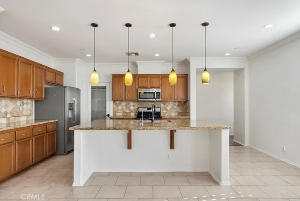 a view of a kitchen with stainless steel appliances granite countertop a stove top oven a sink with wooden floor