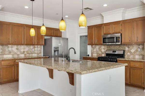 a kitchen with stainless steel appliances granite countertop a sink a stove and cabinets