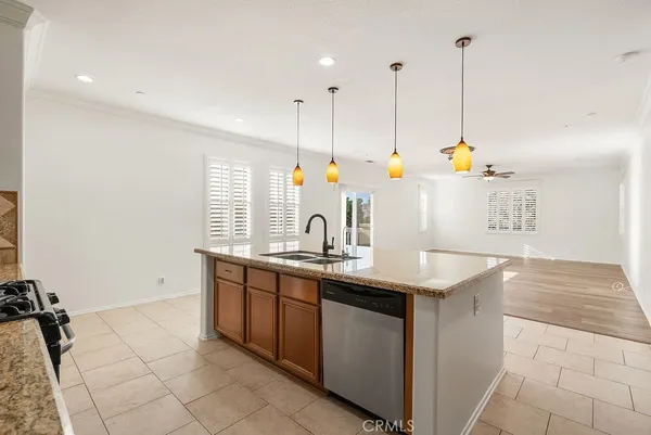 a view of a kitchen with kitchen island white cabinets and sink