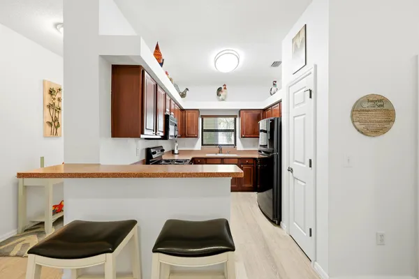 a dining room with wooden floor a chandelier a wooden table and chairs
