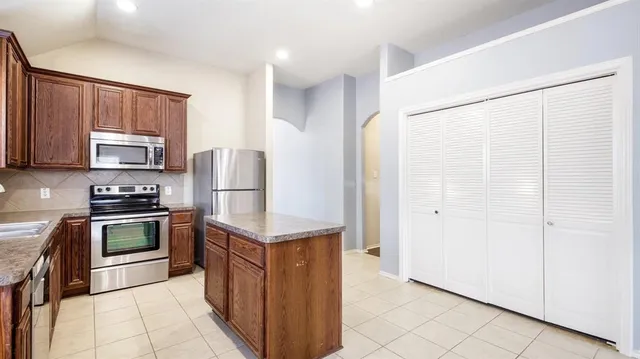 a kitchen with stainless steel appliances granite countertop a refrigerator sink and stove