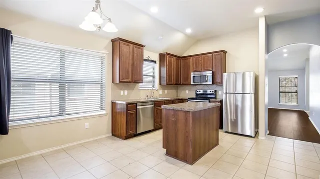 a kitchen with stainless steel appliances granite countertop a refrigerator and a stove top oven