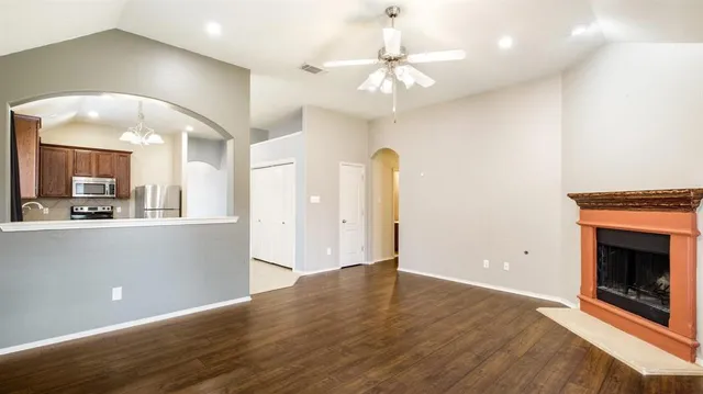 an empty room with wooden floor and fireplace