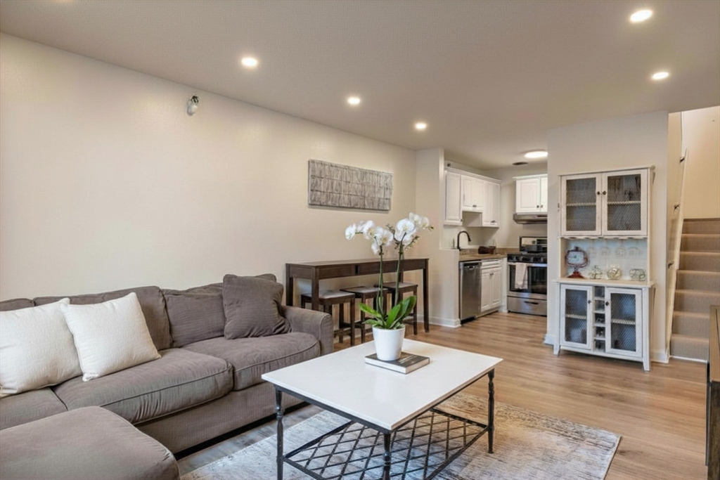 42 8th Street, Unit 2308 Boston, MA 02129 - Photo 2 of 19 a living room with furniture kitchen view and a wooden floor