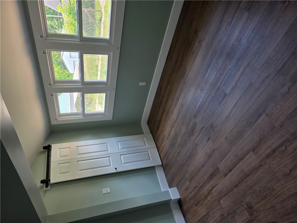 112 Simmons Street Anderson, SC 29625 - Photo 25 of 26 Floor-to-ceiling windows illuminate rich wood flooring, complementing a fresh wall color.