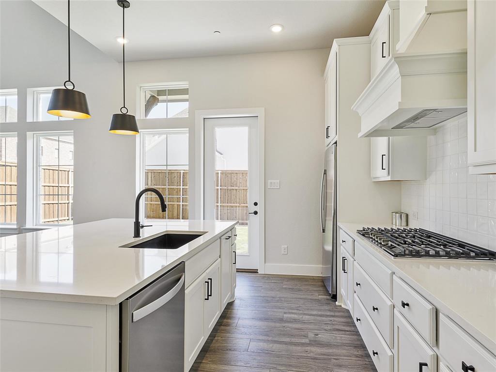 4299 Reeder Rdg Way Frisco, TX 75033 - Photo 12 of 30 a kitchen with stainless steel appliances granite countertop a sink stove and refrigerator